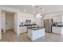 Modern kitchen with white cabinets, granite island, and stainless steel appliances at 18171 W Glenhaven Dr, Goodyear, AZ 85338