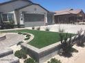 Landscaped front yard with artificial turf and stone accents at 3216 W Melody Dr, Laveen, AZ 85339