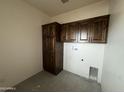 The laundry area features custom wood cabinetry offering ample storage space, plus washer and dryer hookups at 48548 W Long Rifle Rd, Aguila, AZ 85320