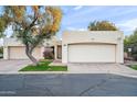 Front view of a tan stucco home with a two-car garage at 5711 N 24Th Pl, Phoenix, AZ 85016