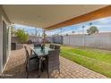 Covered patio with pavers, outdoor dining set, and grassy backyard at 7443 E Taylor St, Scottsdale, AZ 85257