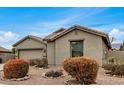 Tan house with a two-car garage and neatly landscaped yard at 7606 E Globemallow Ln, Gold Canyon, AZ 85118