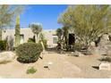 Desert landscaping surrounds this single-story home with a three-car garage at 9580 E Southwind Ln, Scottsdale, AZ 85262