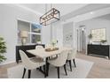 Bright dining room featuring a modern light fixture, six chairs, and a window providing natural light at 10053 E Seismic Ave, Mesa, AZ 85212