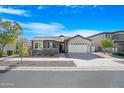 House exterior showcasing a charming curb appeal with landscaping and a two-car garage at 10053 E Seismic Ave, Mesa, AZ 85212