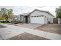 Front view of a charming house with a white garage door and landscaped yard at 10053 E Seismic Ave, Mesa, AZ 85212