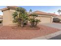 Two story home with tan exterior and lush landscaping at 10828 E Flintlock Dr, Sun Lakes, AZ 85248