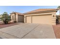 Two-car garage with light tan exterior and a large driveway at 10828 E Flintlock Dr, Sun Lakes, AZ 85248