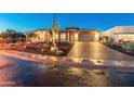 Desert home with brick driveway and Saguaro cactus at night at 11842 W Creosote Dr, Peoria, AZ 85383