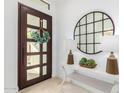 Bright entryway with dark wood door, round mirror, and elegant console table at 16611 S 9Th St, Phoenix, AZ 85048