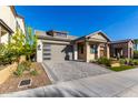 Modern home with gray garage door and paver driveway, inviting landscaping at 16611 S 9Th St, Phoenix, AZ 85048