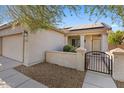 House exterior with solar panels and gated entryway at 19234 W Woodlands Ave, Buckeye, AZ 85326