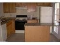 Kitchen with light wood cabinets, a breakfast bar, and appliances at 2138 W Beaubien Dr, Phoenix, AZ 85027