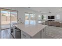 Open concept kitchen with island and view into living room at 22413 N 101St Ave, Peoria, AZ 85383