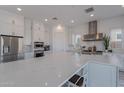 Modern kitchen with white cabinets, large island, and stainless steel appliances at 22413 N 101St Ave, Peoria, AZ 85383