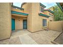 Teal door entry to a light-colored stucco building at 225 W 1St St # 118, Mesa, AZ 85201