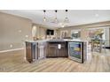 Modern kitchen island with granite countertops and wine cooler at 26119 W Wahalla Ln, Buckeye, AZ 85396