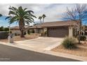 House exterior with a brown garage door and desert landscaping at 26602 S Nicklaus Dr, Sun Lakes, AZ 85248