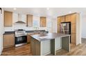 Kitchen boasts stainless appliances, a center island, and lots of wood cabinets at 2707 S 357Th Dr, Tonopah, AZ 85354