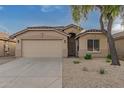 Tan house with a two-car garage and landscaped front yard at 3257 W Five Mile Peak Dr, San Tan Valley, AZ 85144