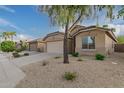 Tan house with a two-car garage and landscaped front yard at 3257 W Five Mile Peak Dr, San Tan Valley, AZ 85144