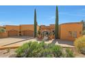 Stunning two-story home with a stucco exterior, arched entryway, and mature landscaping at 37018 N Tree Lined Trl, Carefree, AZ 85377