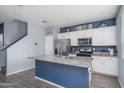 Granite kitchen island and white cabinets with blue accent wall at 416 N 110Th Ave, Avondale, AZ 85323