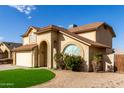 Two-story house with beige exterior, two-car garage, and landscaped lawn at 4250 E Towne Ln, Gilbert, AZ 85234