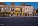 Modern townhomes featuring neutral stucco, black framed windows, and small balconies at dusk at 4354 N 27Th Pl, Phoenix, AZ 85016