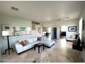 Bright living room with a large sectional sofa and tile flooring at 45717 W Ranch Rd, Maricopa, AZ 85139