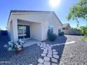 Exterior backyard features a walkway of stepping stones, with desert landscaping, and a covered patio at 7284 E Gamebird Way, San Tan Valley, AZ 85143