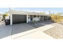 Charming single story home with a black garage door and landscaped yard at 7301 E Almeria Rd, Scottsdale, AZ 85257