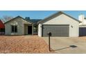 Newly renovated single-story home with a modern gray garage door at 7602 W Minnezona Ave, Phoenix, AZ 85033