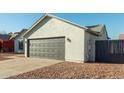 Single-story home with gray garage door and a gravel driveway at 7602 W Minnezona Ave, Phoenix, AZ 85033