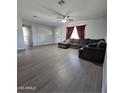 Bright living room featuring gray laminate floors and a comfortable sectional sofa at 1839 E Indigo St, Mesa, AZ 85203