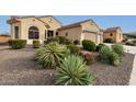 Tan two-story house with a three-car garage and nicely landscaped yard at 20359 N 262Nd Dr, Buckeye, AZ 85396