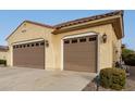 Tan two-story house with a three-car garage and landscaped yard at 20359 N 262Nd Dr, Buckeye, AZ 85396