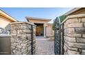 Ornate iron gate opens to a brick-paved pathway, leading to the home's entrance at 211 E Desert Wind Dr, Phoenix, AZ 85048