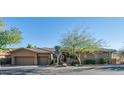 This single-story home features a two-car garage and desert landscaping at 211 E Desert Wind Dr, Phoenix, AZ 85048