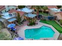 Stunning aerial view of the backyard oasis with pool, putting green, outdoor kitchen, and landscaped patio at 2131 W Ironwood Dr, Chandler, AZ 85224