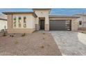 Modern single-story house with stone accents and a gray garage door at 21411 W Meadowbrook Ave, Buckeye, AZ 85396