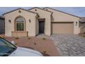 Beige house exterior with a dark door and paved driveway at 21418 W Meadowbrook Ave, Buckeye, AZ 85396