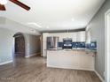 Open concept kitchen with island and wood-look flooring at 2215 E Des Moines Cir, Mesa, AZ 85213