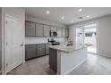 Modern kitchen with gray cabinets, granite island, and backyard access at 2575 E Bluff Spring Ave, Apache Junction, AZ 85119