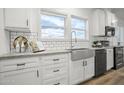 Modern kitchen with white cabinets, farmhouse sink, and stainless steel appliances at 2693 S 357Th Dr, Tonopah, AZ 85354