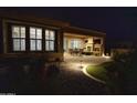 Night view of covered patio with fireplace and outdoor seating area at 27028 W Oraibi Dr, Buckeye, AZ 85396