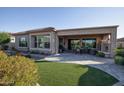 Covered patio with fireplace, outdoor dining area, and artificial turf at 27028 W Oraibi Dr, Buckeye, AZ 85396