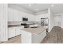 L-shaped kitchen with island, stainless steel appliances, and light countertops at 2929 E Birdsong Ave, San Tan Valley, AZ 85143