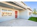 Front entrance with red door and security gate, a small covered patio, and artificial turf at 2929 E Broadway Rd # 13, Mesa, AZ 85204