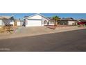 Single-story house with gray exterior, white garage door, and a palm tree in front at 7210 W Pasadena Ave, Glendale, AZ 85303